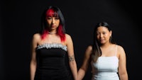 two asian women standing next to each other on a black background