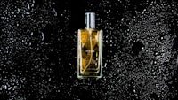 a bottle of perfume sitting on a black background