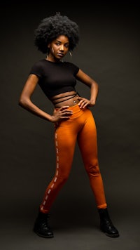 a woman in orange pants posing for a photo