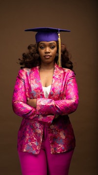 a woman in a purple suit with a graduation cap