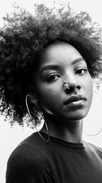 a black woman with afro hair and hoop earrings